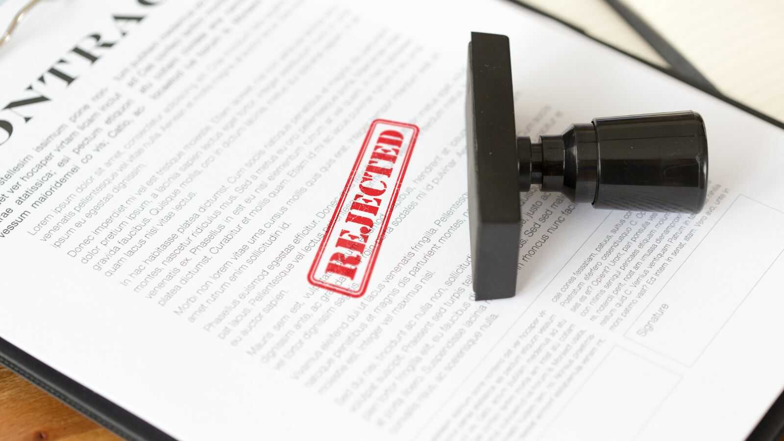 Bouwondernemer leest aangetekende brief van verzekeraar met weigeringsbeslissing op zijn bureau